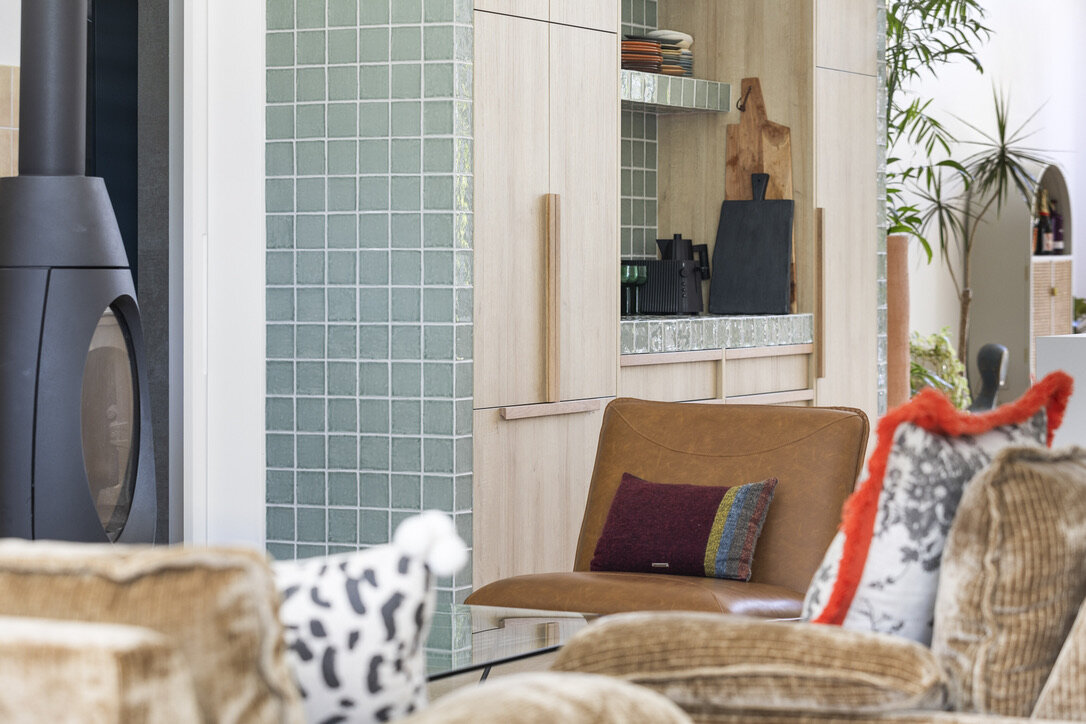 Modern architect designed kitchen, green tiled surround, timber laminate cabinets
