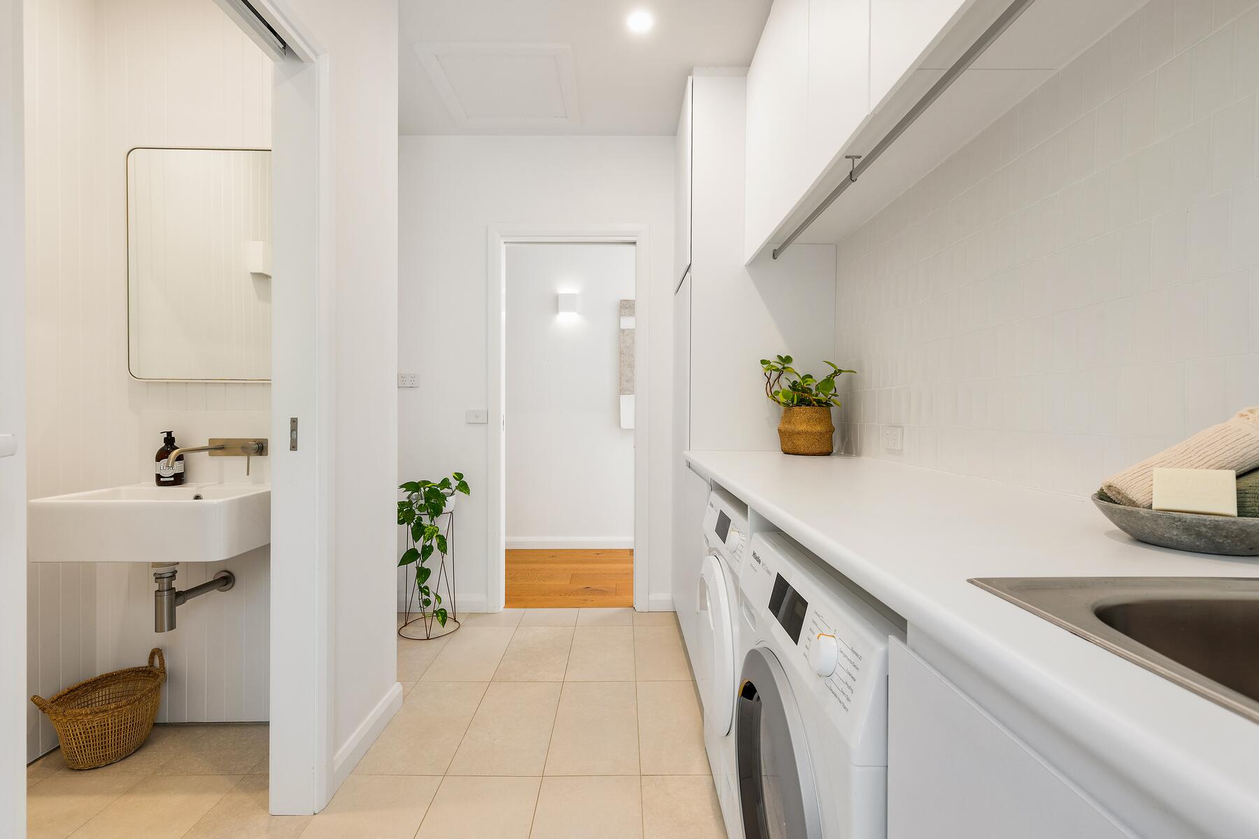 Modern architect designed alterations and additions white laundry with cream floor tiles
