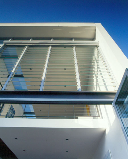 Modern architect designed house with louvred glass windows looking up to mezzanine level