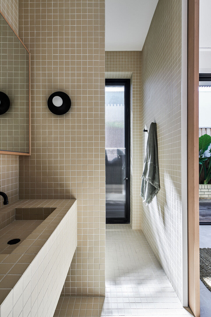 Modern architect designed home tiled bathroom reeded glass vertical window in shower