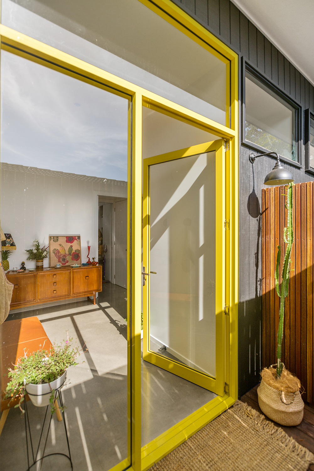 Modern yellow framed glass front door concrete floors