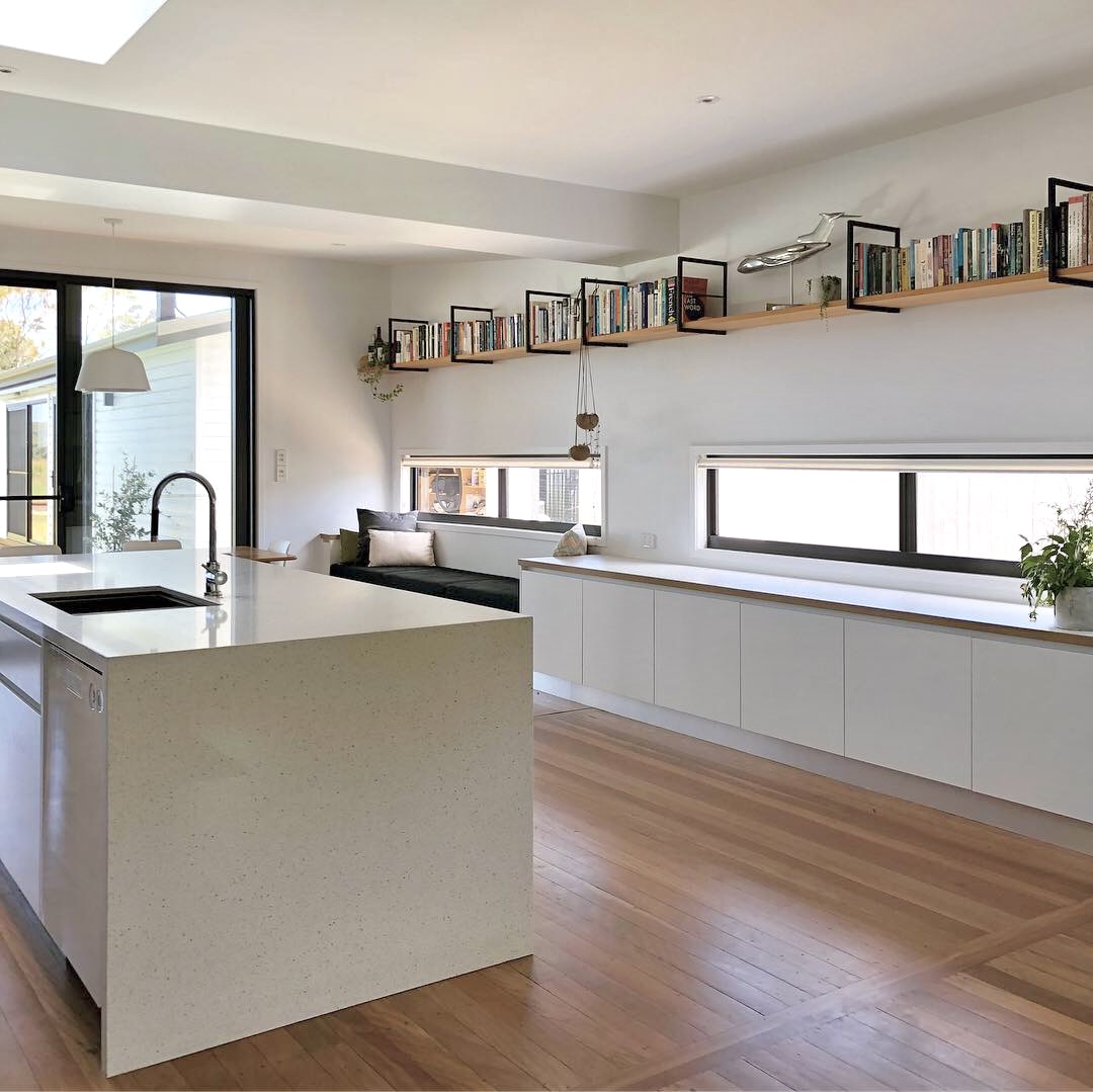 Modern architect designed renovations with white stone benchtops with waterfall edge and sideboard, horizontal strip windows
