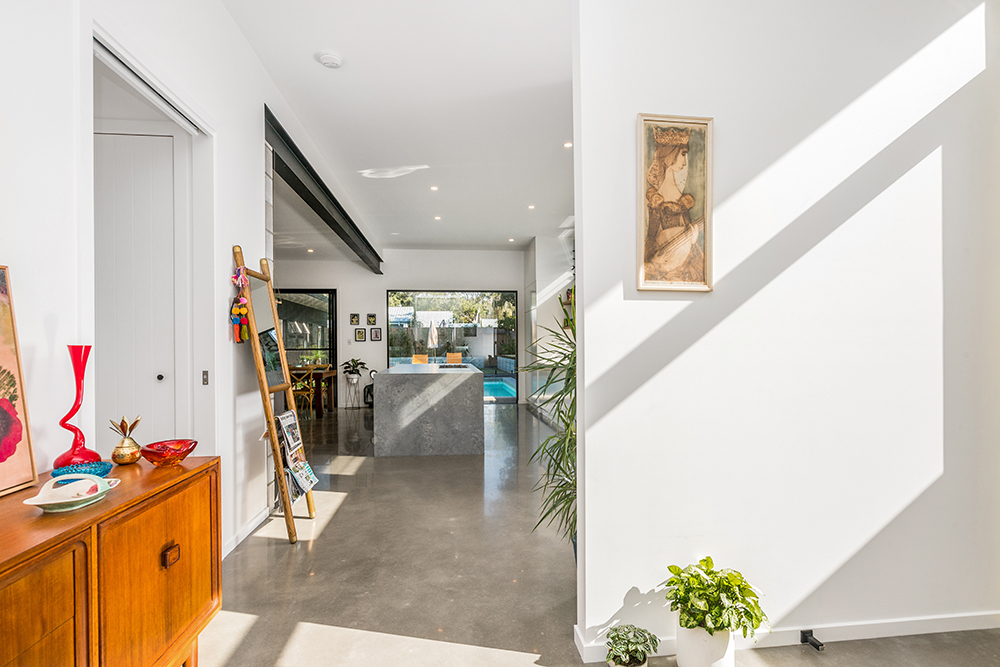 Modern architect designed house with concrete floors looking towards kitchen and large picture window
