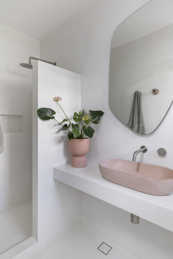 Modern architect designed ensuite with microcement rendered walls and benchtops, pink concrete basin