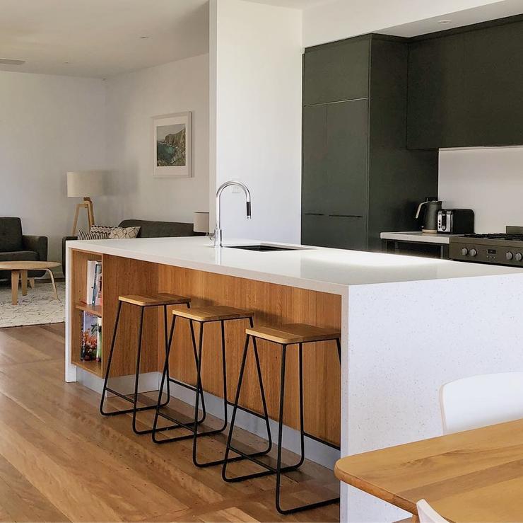 Modern architect deisgned kitchen with white Caesarstone benchtops, timber veneer and black cabinets